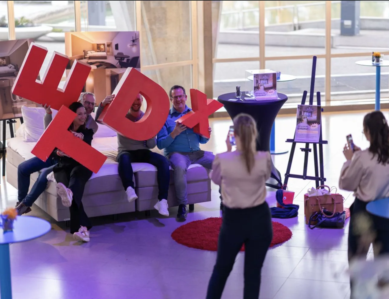Bezoekers poseren met de rode TEDx-letters in de foyer