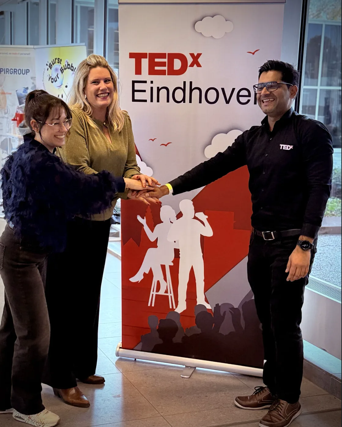 Drie mensen bij de TEDxEindhoven-banner