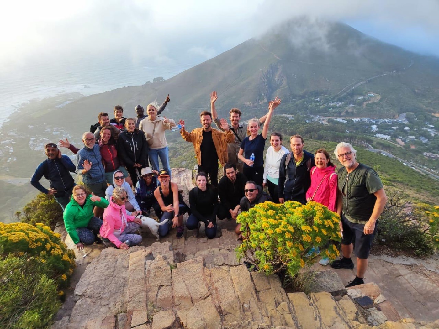 Wandelgroep op een bergpad tussen gele bloemen