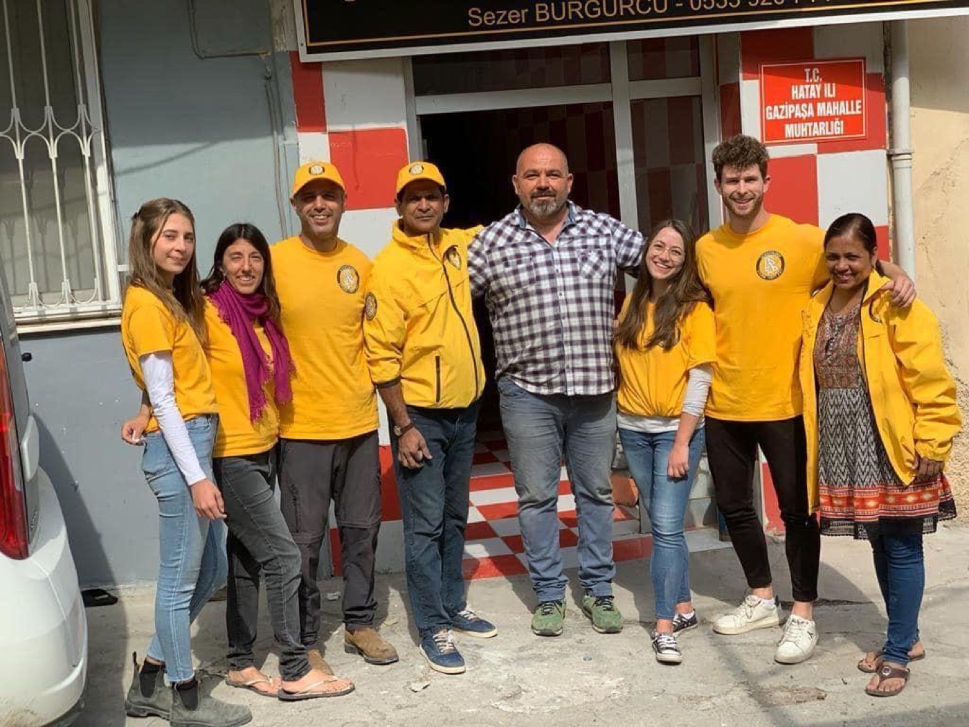 Met een team in gele shirts voor een gebouw