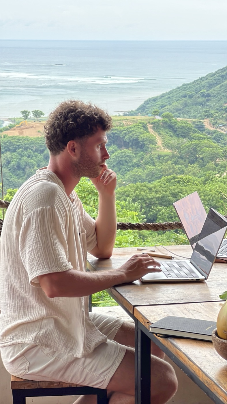 Werkend aan de laptop met uitzicht op zee en jungle