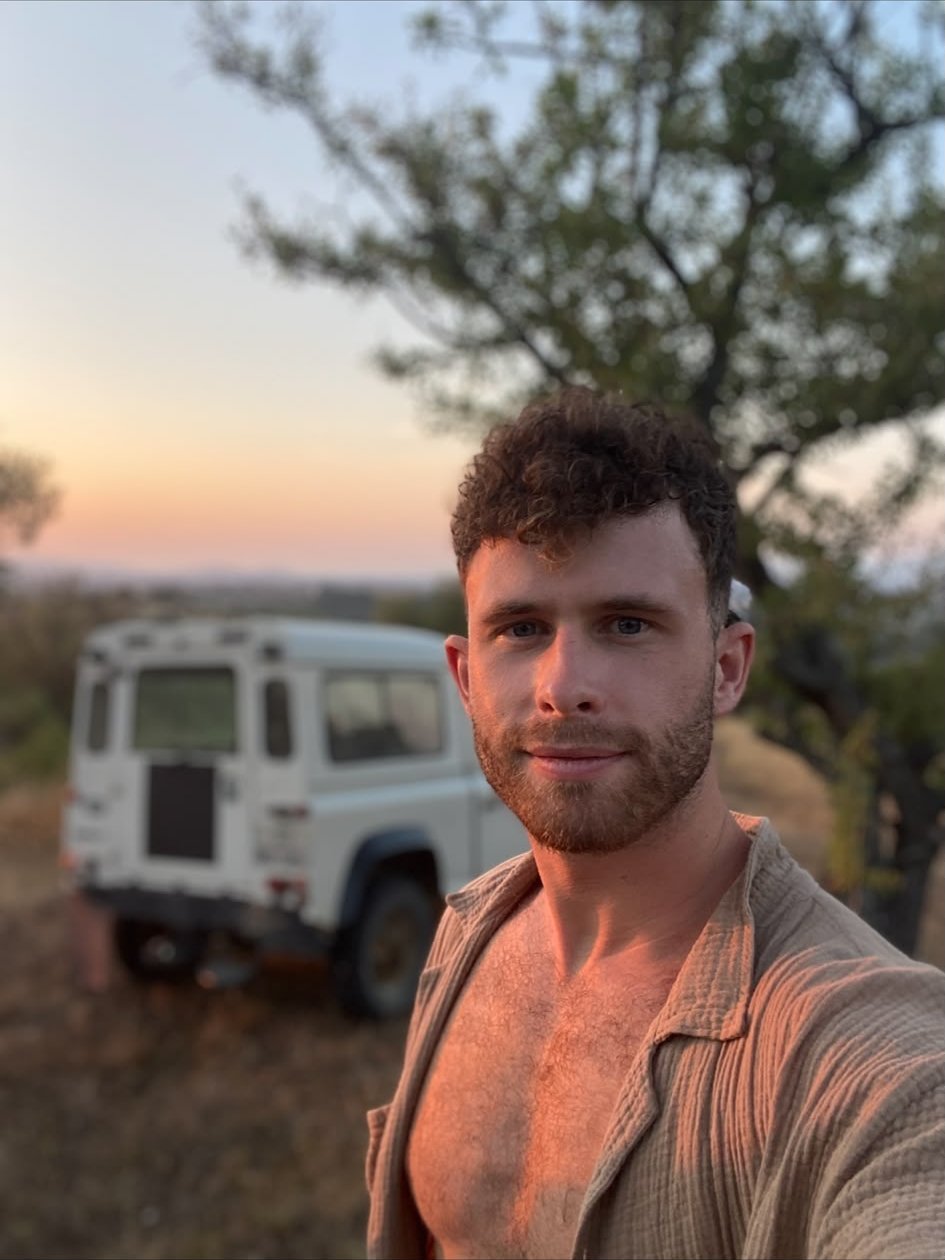Selfie voor een witte terreinwagen in de avondzon